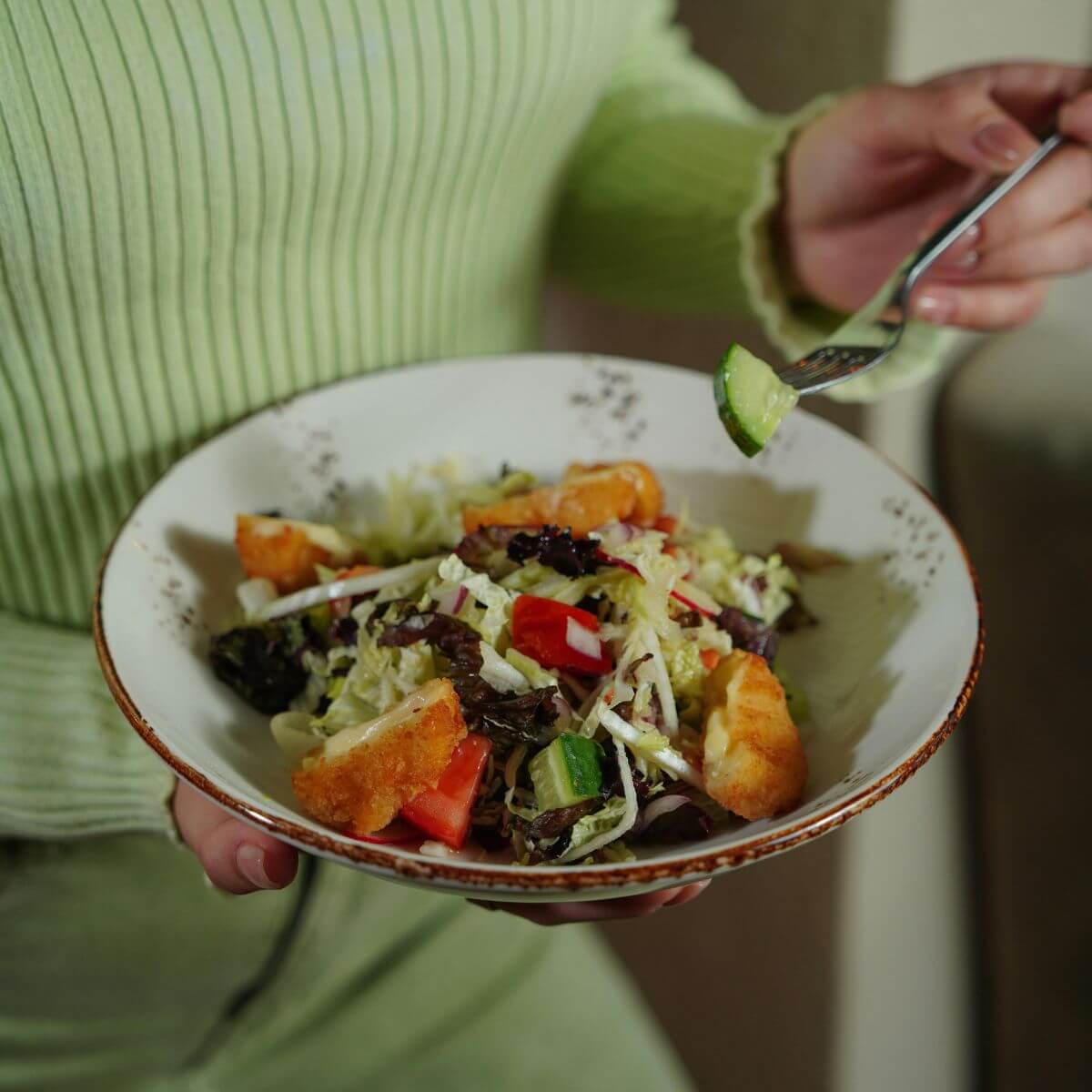 Woman holding a colorful gut-friendly vegetable salad bowl